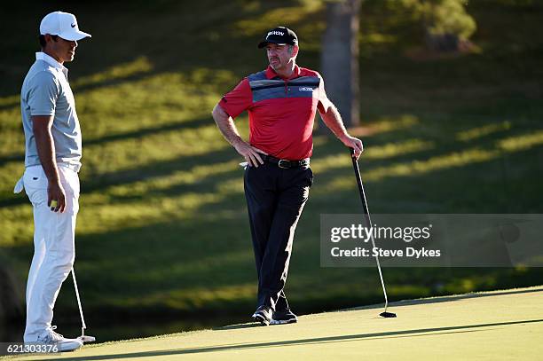 Brooks Koepka of the United States talks to Rod Pampling of Australia on the 18th green during the third round of the Shriners Hospitals For Children...