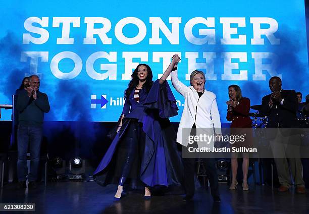 Democratic presidential nominee former Secretary of State Hillary Clinton raises her arms with recording artist Katy Perry during a get-out-the-vote...