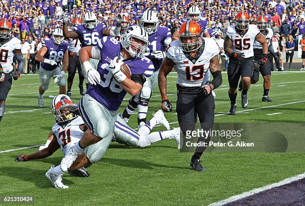 Full back Winston Dimel of the Kansas State Wildcats rushes past free safety Jordan Sterns of the Oklahoma State Cowboys for a touchdown during the...