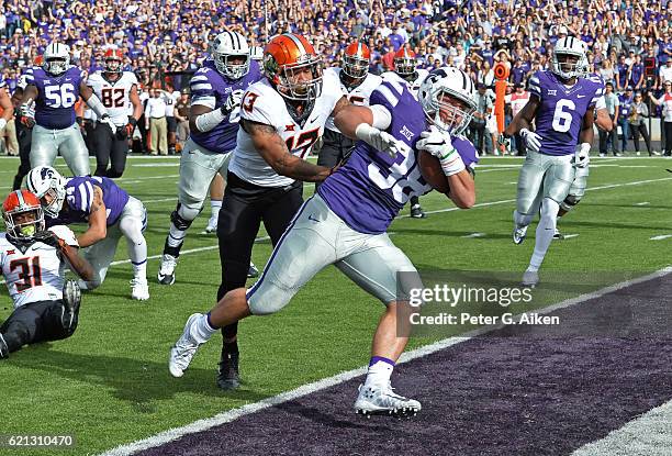 Full back Winston Dimel of the Kansas State Wildcats rushes past free safety Jordan Sterns of the Oklahoma State Cowboys for a touchdown during the...