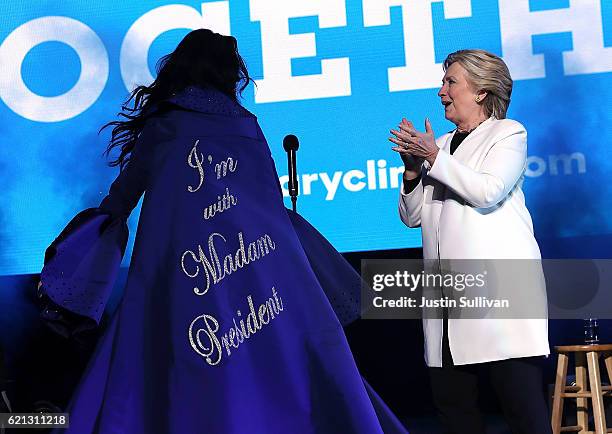 Democratic presidential nominee former Secretary of State Hillary Clinton looks at a cape worn by recording artist Katy Perry during a...