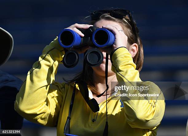 Michigan fan uses a pair of binoculars to get a better view of the Wolverines while they were warming up before taking on Maryland on November 11,...