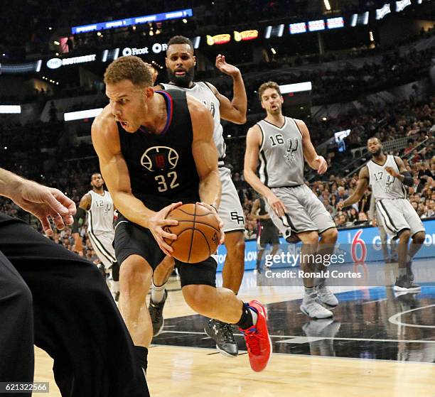 Blake Griffin of the Los Angeles Clippers save the ball from going out of bounds as Patty Mills of the San Antonio Spurs watches during game between...