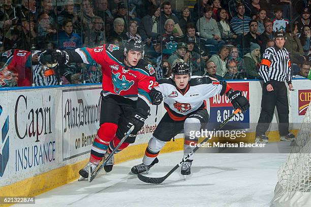 David Quenneville of the Medicine Hat Tigers keeps his eye on the puck as he checks Cal Foote of the Kelowna Rockets behind the net during second...