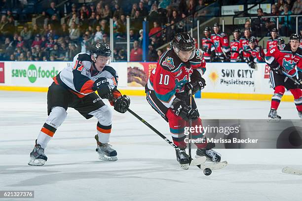 Gary Haden of the Medicine Hat Tigers stick checks Nick Merkley of the Kelowna Rockets during third period at Prospera Place on November 5, 2016 in...