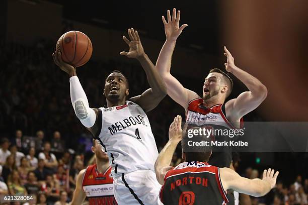 Cedric Jackson of United drives to the basket under pressure from AJ Ogilvy and Mitch Norton of the Hawks during the round five NBL match between the...