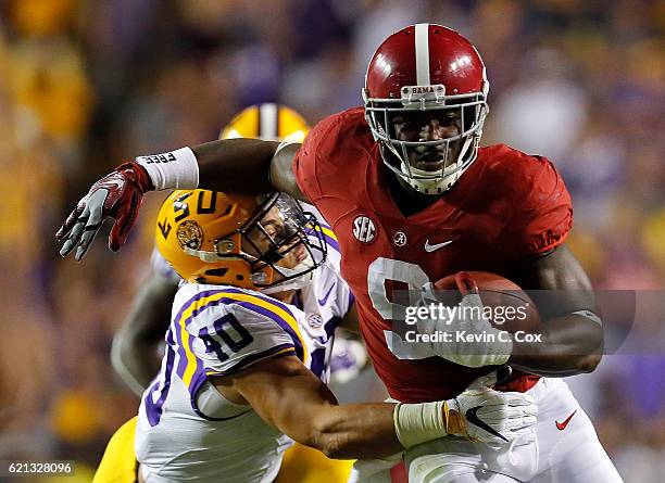 Bo Scarbrough of the Alabama Crimson Tide attempts to break a tackle by Duke Riley of the LSU Tigers at Tiger Stadium on November 5, 2016 in Baton...