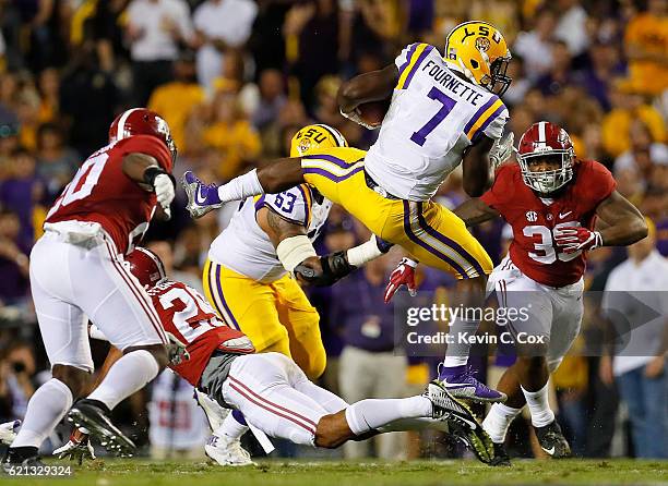 Leonard Fournette of the LSU Tigers leaps over Minkah Fitzpatrick of the Alabama Crimson Tide at Tiger Stadium on November 5, 2016 in Baton Rouge,...