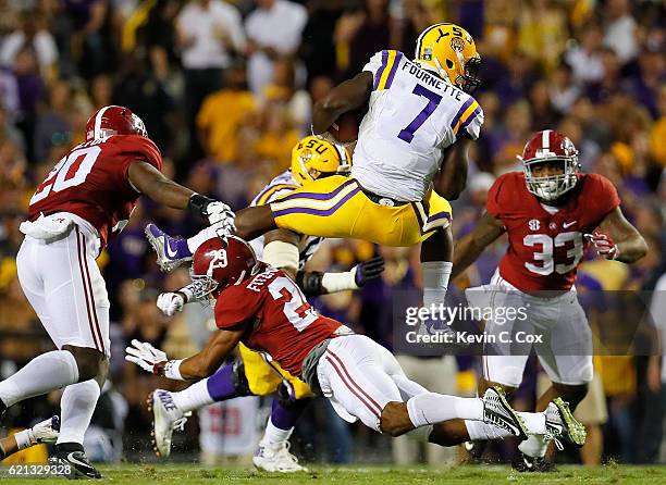 Leonard Fournette of the LSU Tigers leaps over Minkah Fitzpatrick of the Alabama Crimson Tide at Tiger Stadium on November 5, 2016 in Baton Rouge,...