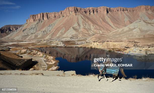 In this photograph taken on November 5 an Afghan man rides a horse overlooking Band-e-Amir lake, the first national park in Afghanistan in the...