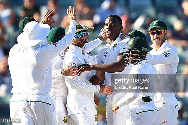 Kagiso Rabada of South Africa celebrates with team mates after dismissing Adam Voges of Australia during day four of the First Test match between...