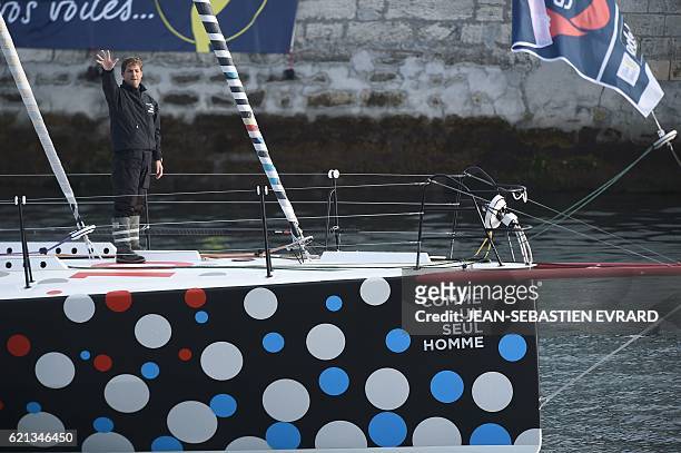 French skipper Eric Bellion waves goodbye from his class Imoca monohull "Comme un seul homme" as he leaves to take the start of the Vendee Globe solo...