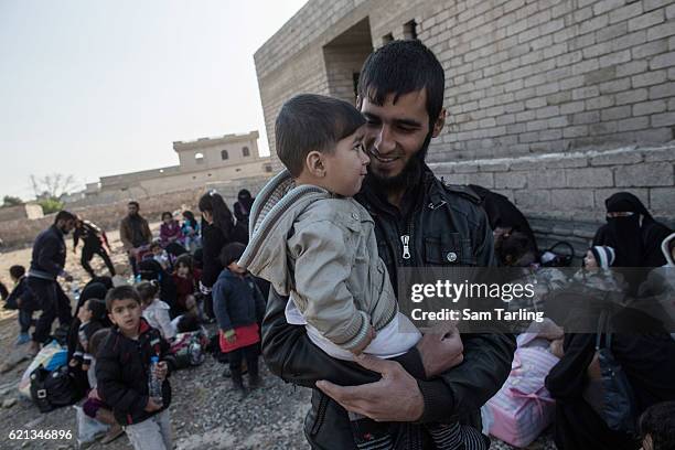 Civilians wait to be put on lorries as they flee from the Zahara neighbourhood on the north eastern edge of Mosul as fighting continues nearby, on...