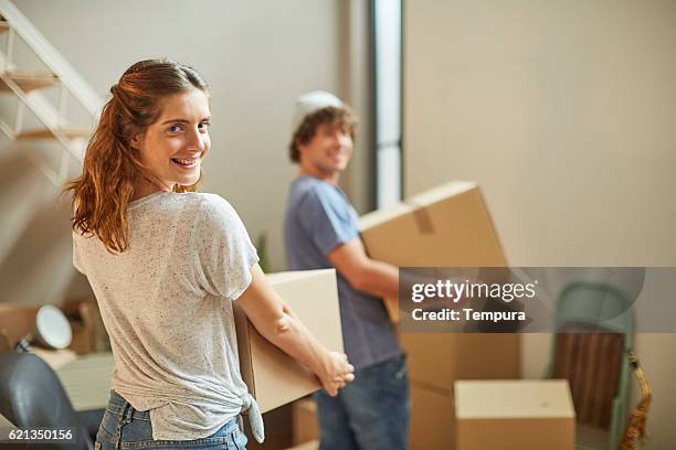 moving home new beginnings.  couple carrying boxes. - man boxes moving home stock pictures, royalty-free photos & images