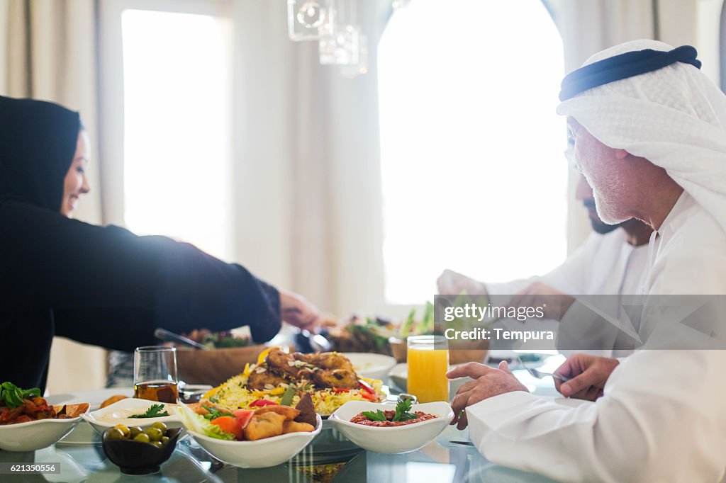 Family gathering, three generations eating traditional food.
