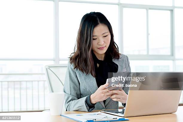 young businesswoman using mobile phone and laptop - sending stock pictures, royalty-free photos & images