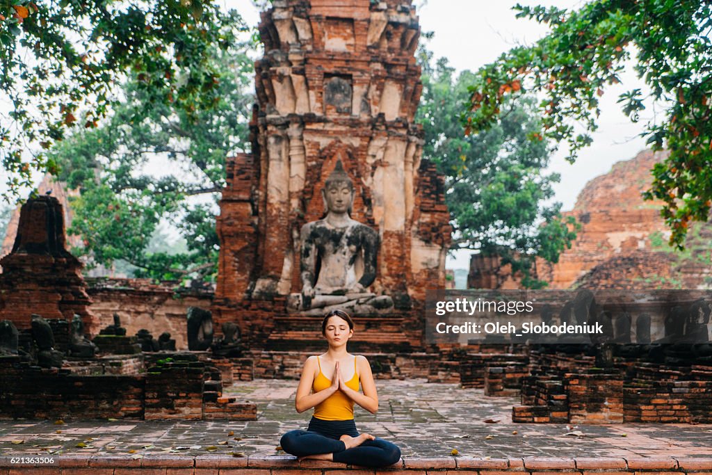 Donna che fa yoga vicino alle rovine del Tempio Buddista