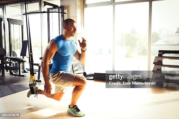 homme faisant des exercices de jambes avec des sangles de suspension à la salle de gym. - jambes hommes photos et images de collection