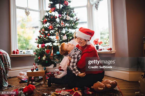 grandmother with her grandson on christmas day - christmas morning stock pictures, royalty-free photos & images