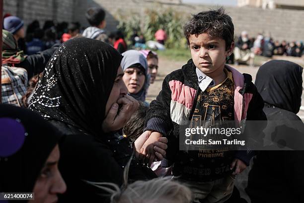 Civilians react after a mortar lands nearby while they wait to be put on lorries as they flee from the Zahara neighbourhood on the north eastern edge...