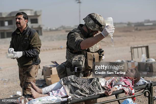 Volunteer from the Academy of Emergency Medicine helps a wounded child in the Zahara neighbourhood on the north eastern edge of Mosul as fighting...
