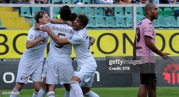 Milan's forward from Spain Suso celebrates with teammates after scoring during the Italian Serie A football match Palermo vs AC Milan on November 6,...