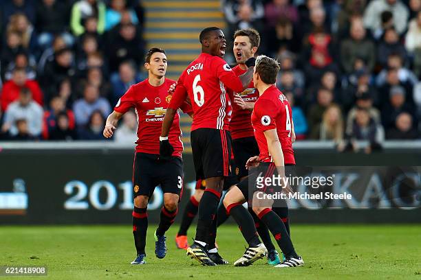 Paul Pogba of Manchester United celebrates scoring his sides first goal with team mates during the Premier League match between Swansea City and...