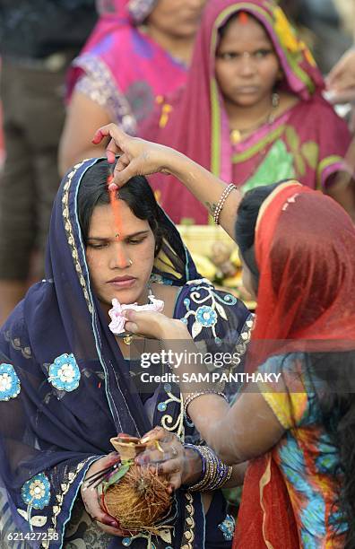 Indian Hindu devotees prepare to offer prayers to the Sun god during the Chhath Festival on the banks of Sabarmati river in Ahmedabad on November 6,...