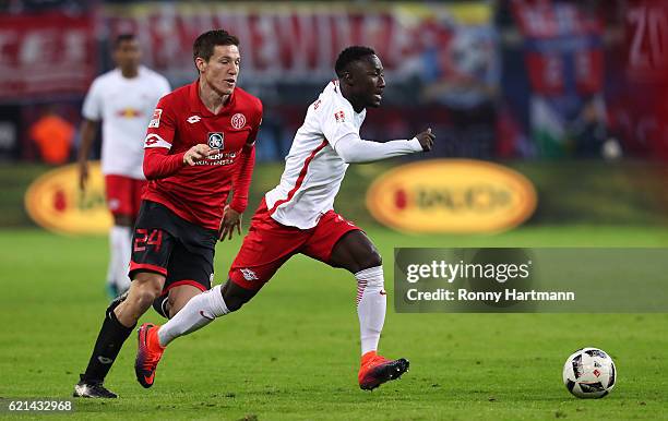 Naby Deco Keita of Leipzig and Gaetan Bussmann of Mainz vie during the Bundesliga match between RB Leipzig and 1. FSV Mainz 05 at Red Bull Arena on...
