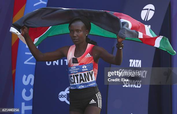 Mary Keitany of Kenya celebrates with the Kenyan flag after finishing first in the Professional Women's Division during the 2016 TCS New York City...