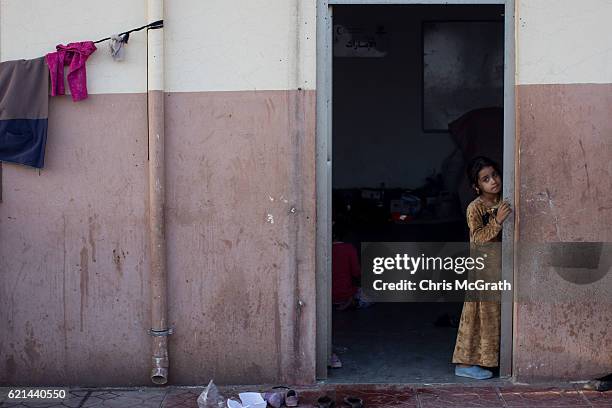 Young girl waits at a food distribution center at an IDP camp in Debaga on November 6, 2016 in Debaga, Iraq. The camp is full to capacity, housing...