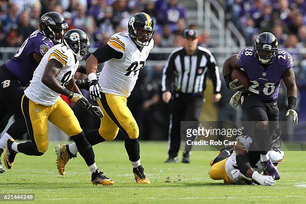 Running back Terrance West of the Baltimore Ravens carries the ball against outside linebacker Jarvis Jones of the Pittsburgh Steelers in the first...
