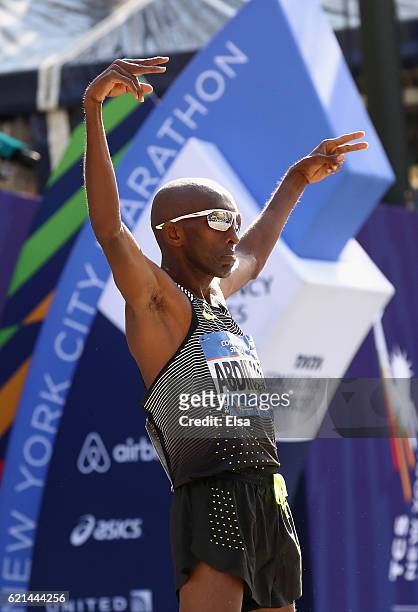 Abdi Abdirahman of the United States celebrates after he crosses the finish line to finish third in the Professional Men's Division during the 2016...
