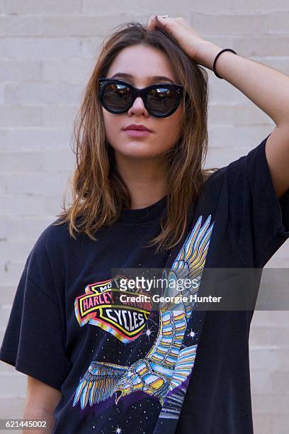 Lily Montasser wearing black oversized vintage cotton Harley-Davidson rock tee with print, silver ring and oversized black Celine sunglasses on...