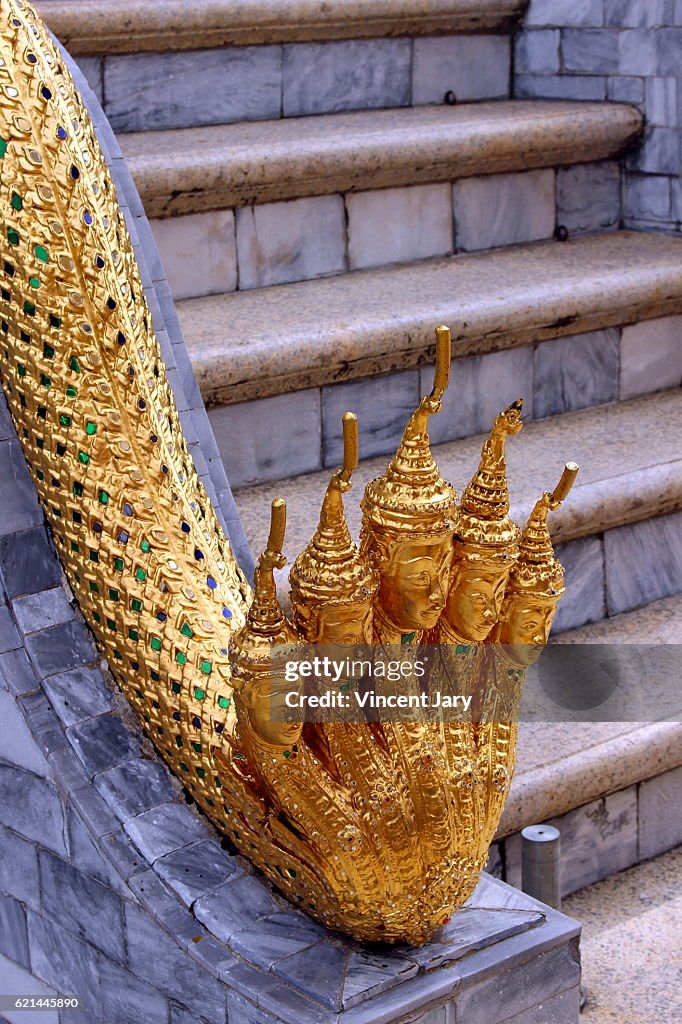 Gold sculpture snake and Buddha heads Bangkok Thailand