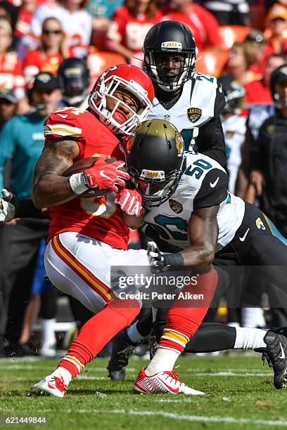 Running back Knile Davis of the Kansas City Chiefs is tackled by outside linebacker Telvin Smith of the Jacksonville Jaguars at Arrowhead Stadium...