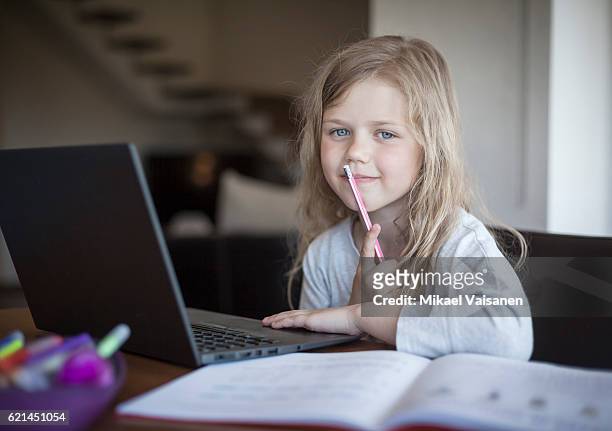 portrait of young girl doing her school work with laptop - young girls homework stockfoto's en -beelden