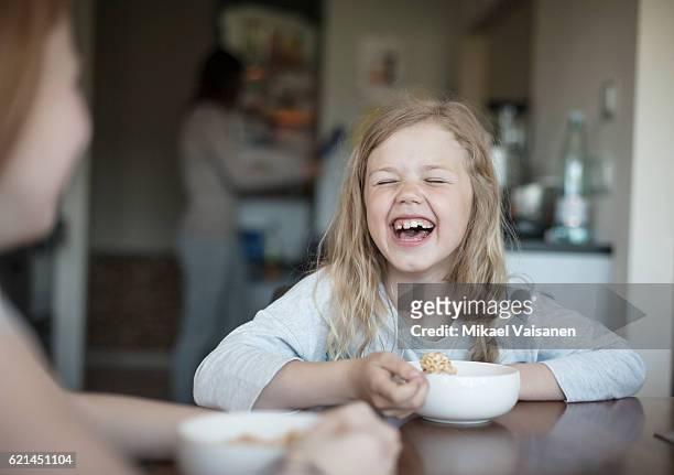 2 young girls having cereals for breakfast - colazione bambini foto e immagini stock