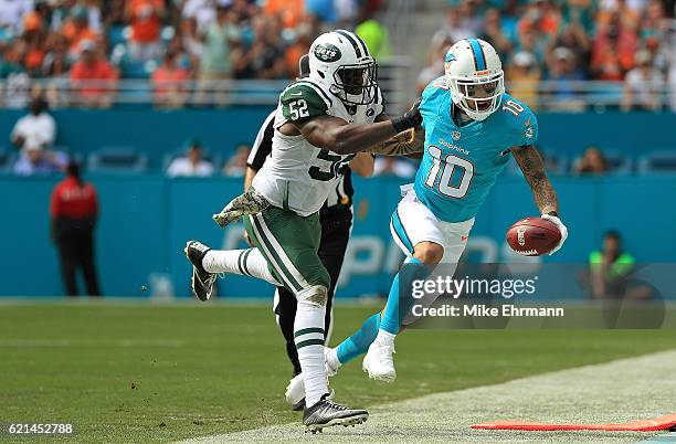 Kenny Stills of the Miami Dolphins is forced out of bounds by David Harris of the New York Jets during a game at Hard Rock Stadium on November 6,...