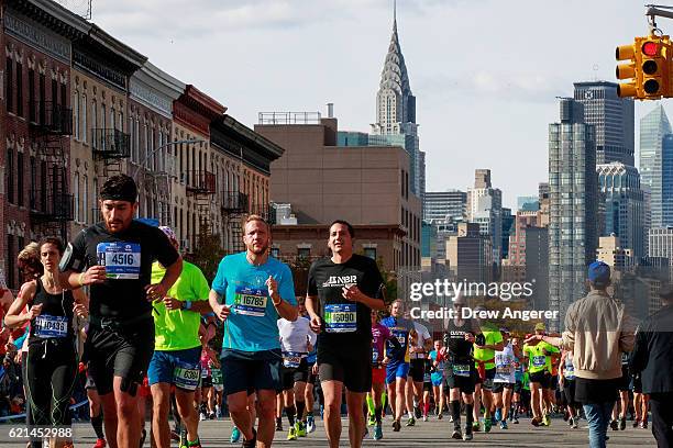 With the Chrysler building behind them, runners make their way through Long Island City during the 2016 TCS New York City Marathon, November 6, 2016...