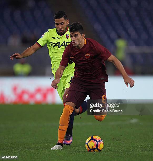 Diego Perotti of AS Roma competes for the ball with Saphir Taider of Bologna FC during the Serie A match between AS Roma and Bologna FC at Stadio...