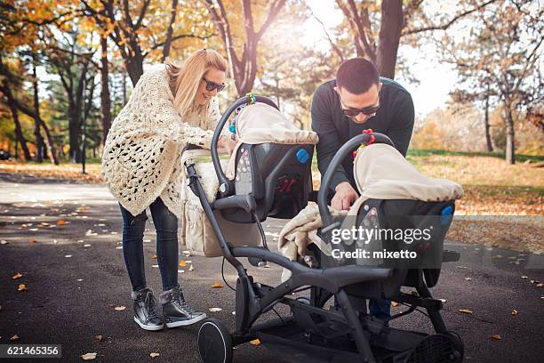 glückliche familie  - baby pram in the park stock-fotos und bilder