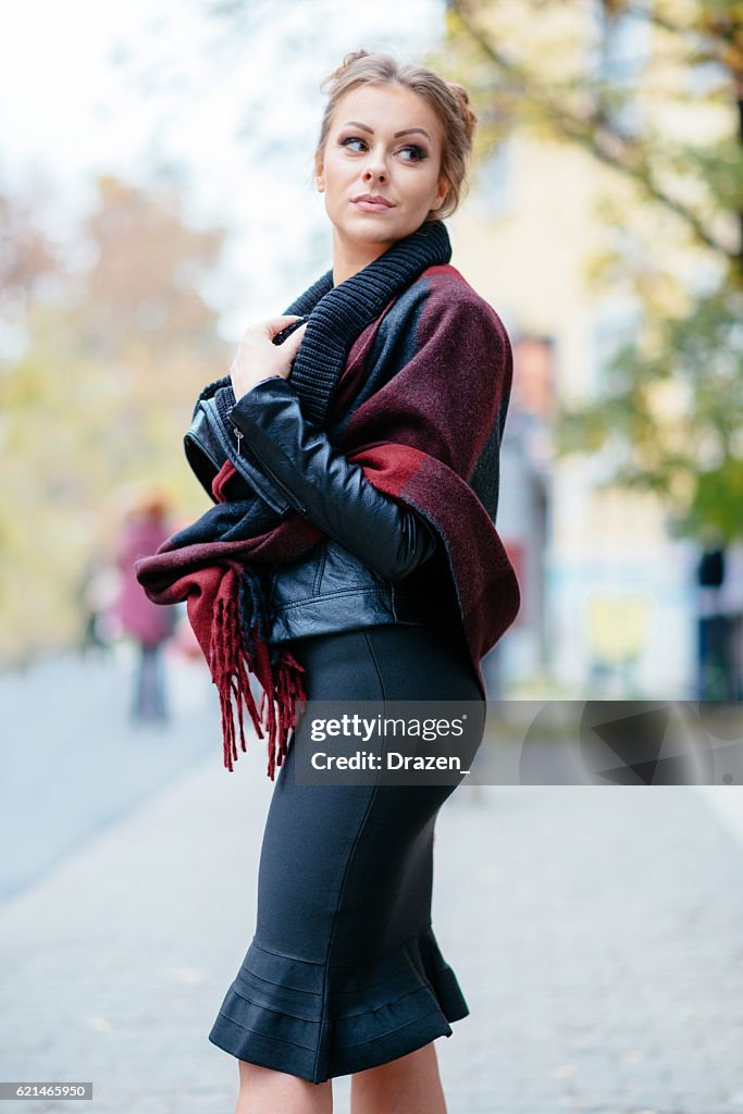 Happy woman in red plaid poncho and skirt