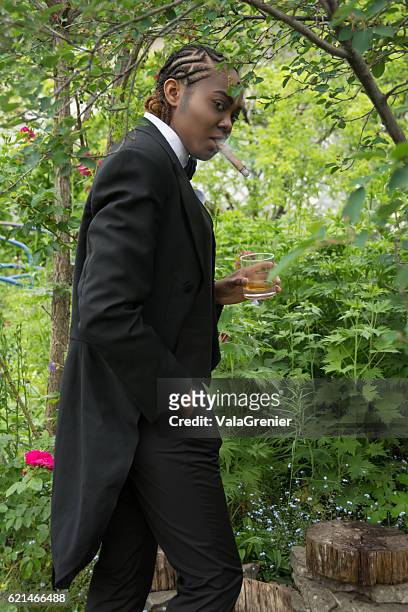 young black woman in male drag, side view standing outdoors. - tail coat stock pictures, royalty-free photos & images