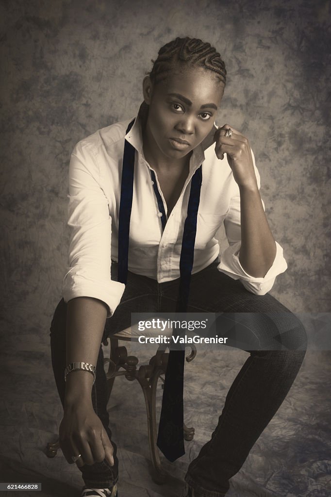 Young black woman in male drag, monochrome front view, studio.