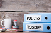 Policies and Procedure. Two binders on desk