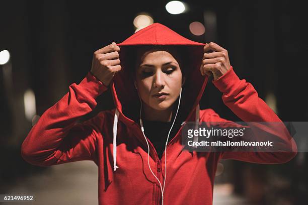 young athlete starting her workout at night - hooded shirt stock pictures, royalty-free photos & images