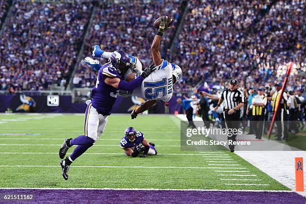 Golden Tate of the Detroit Lions leaps into the end zone for the go ahead touchdown while being tackled by Andrew Sendejo of the Minnesota Vikings...