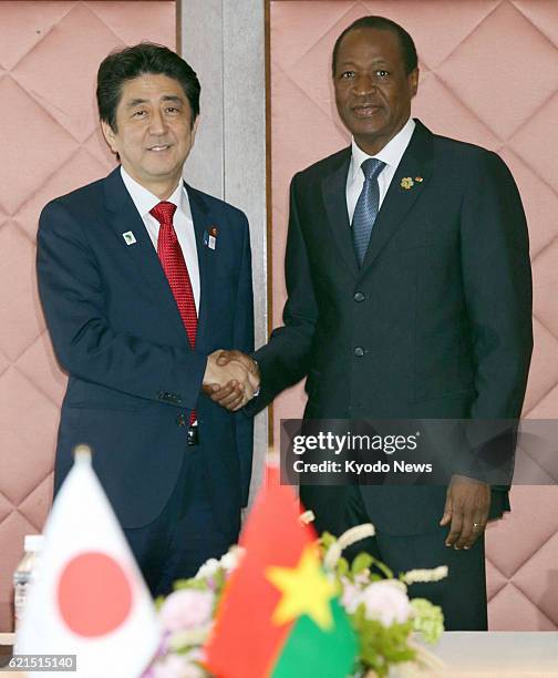 Japan - Japanese Prime Minister Shinzo Abe and Burkina Faso's President Blaise Compaore shake hands ahead of their talks at a hotel in Yokohama, near...