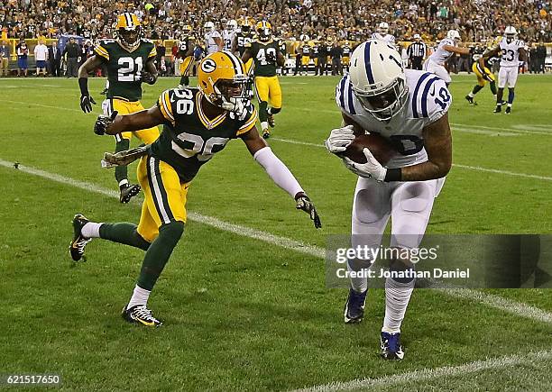 Donte Moncrief of the Indianapolis Colts catches a touchdown pass next to LaDarius Gunter of the Green Bay Packers at Lambeau Field on November 6,...